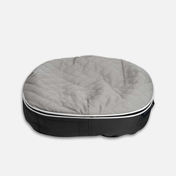 Hringlaga, grá ThermoQuilt hundaseng með bólstruðu yfirborði og dökkgráum botni úr efni, á einföldum ljósum bakgrunni.
