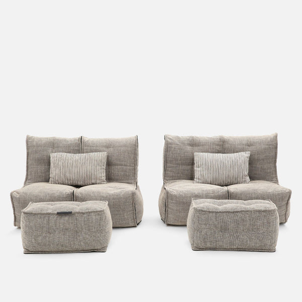 Tveir nútímalegir tveggja manna sófar úr beige efni, sem minna á glæsilegan hönnunarsófa, með samsvarandi rétthyrndum fótum og samsvarandi röndóttum koddum á lendarhrygg, allt á hvítum bakgrunni.